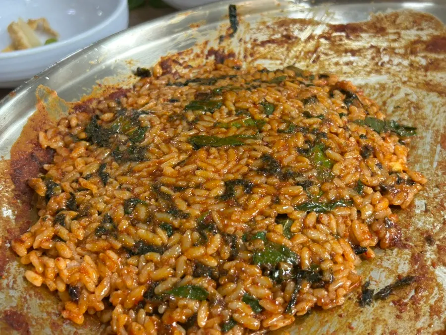 Fried rice being made with seaweed, vegetables, and cheese