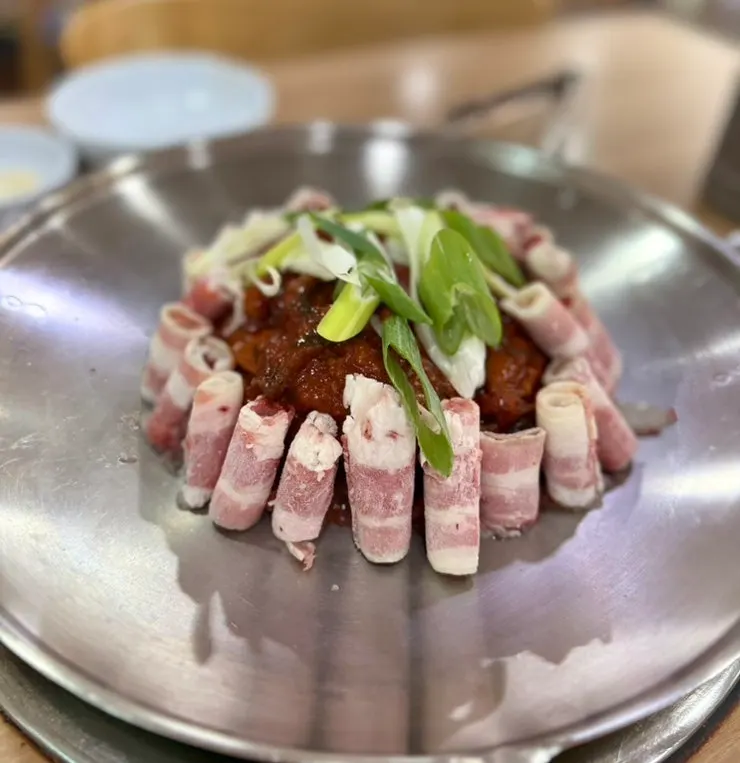 Hwasan Jjukkumi cooking on the grill by a staff member