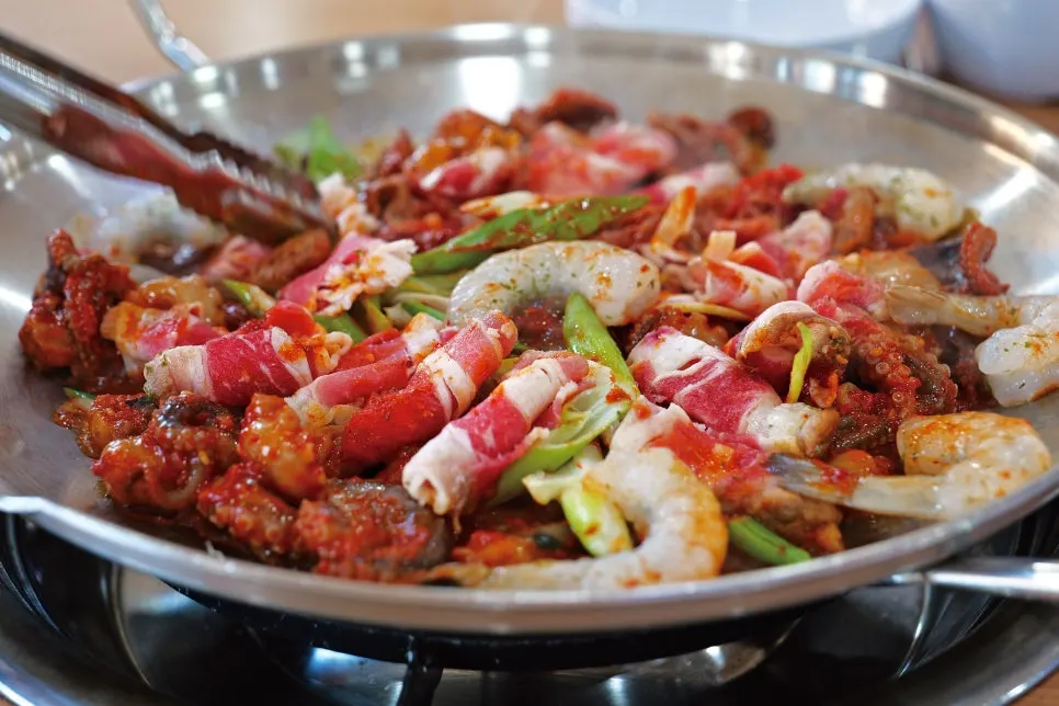 Octopus and beef belly cooking on the griddle