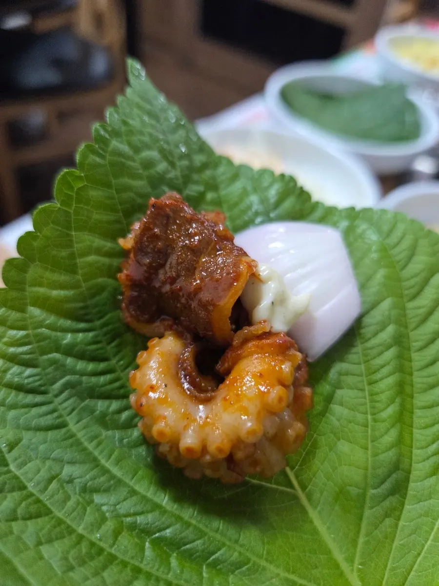 깻잎에 콩나물과 쌈무를 올린 쭈꾸미쌈