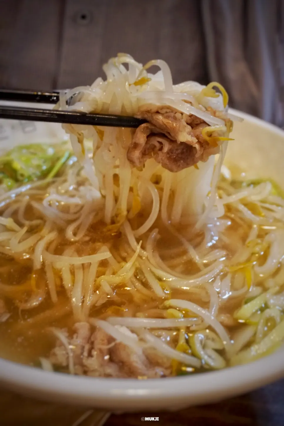Pho noodles lifted up with chopsticks