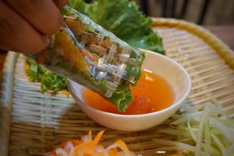 A banh xeo wrap dipped in house-made sauce