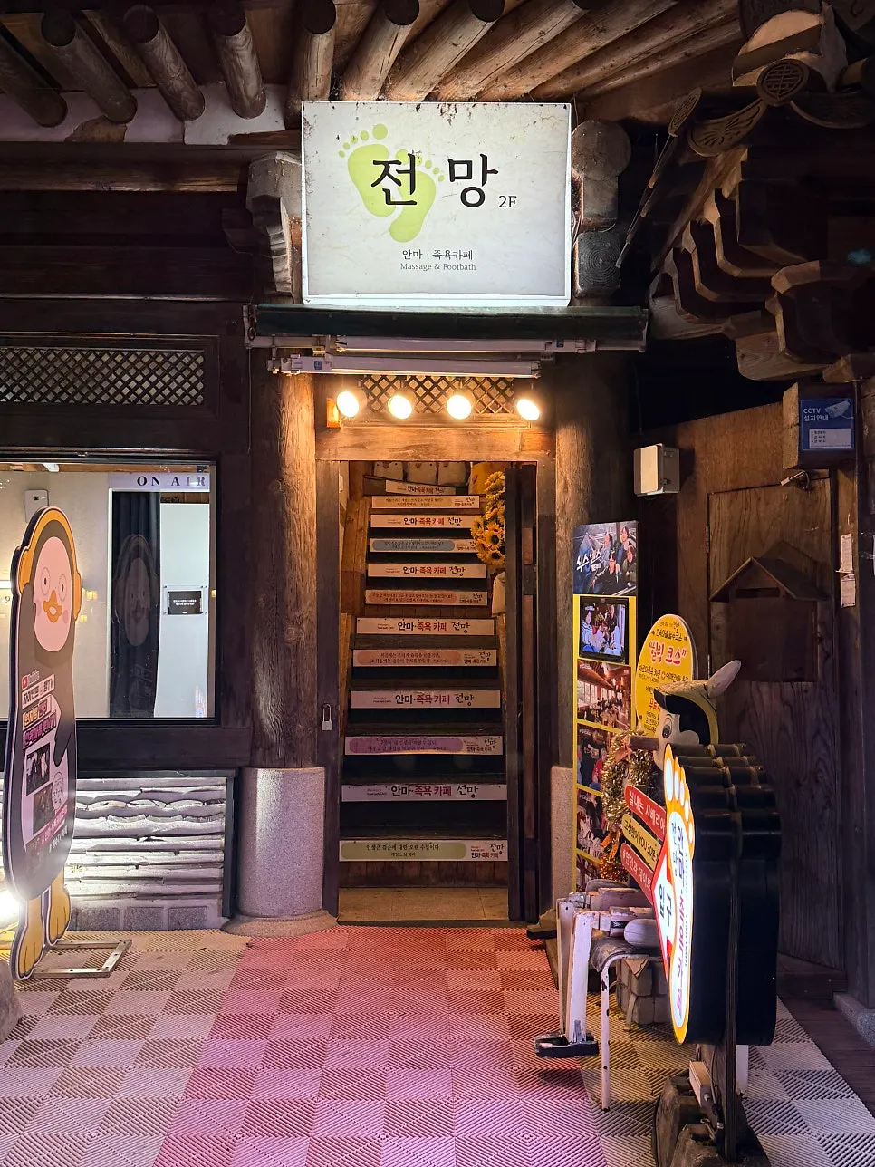 노란 조명이 켜진 한옥 외관과 발바닥 간판