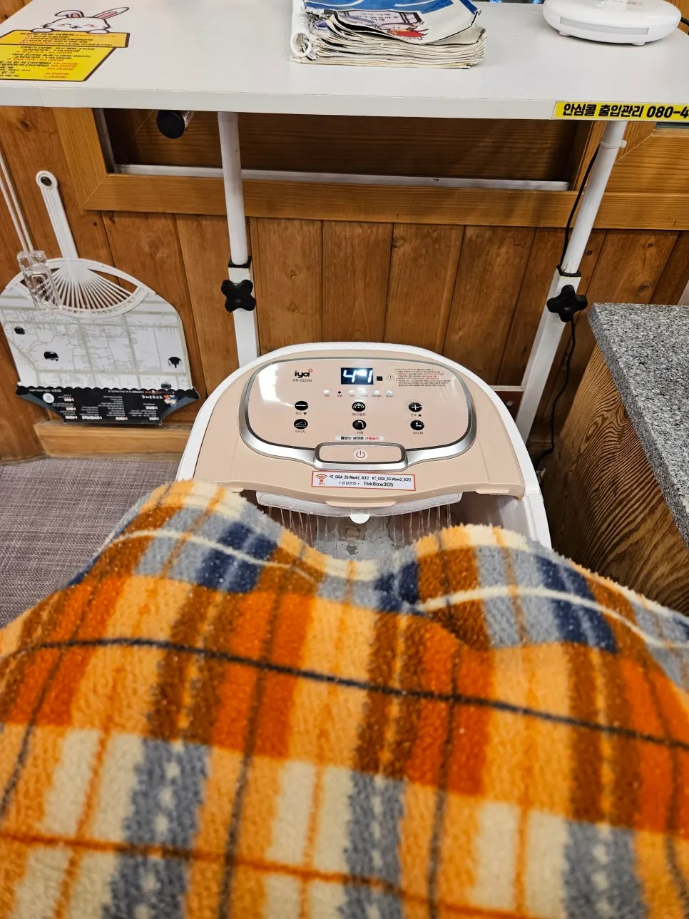 지압판이 깔린 족욕기에 발을 담근 모습