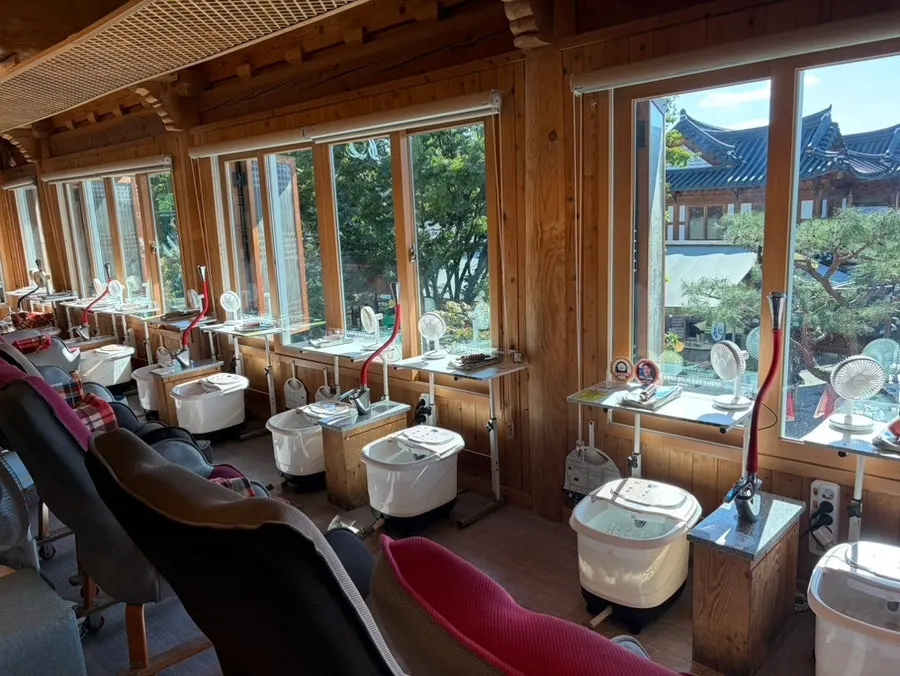 Foot bath machines lined up by the window overlooking Hanok Village