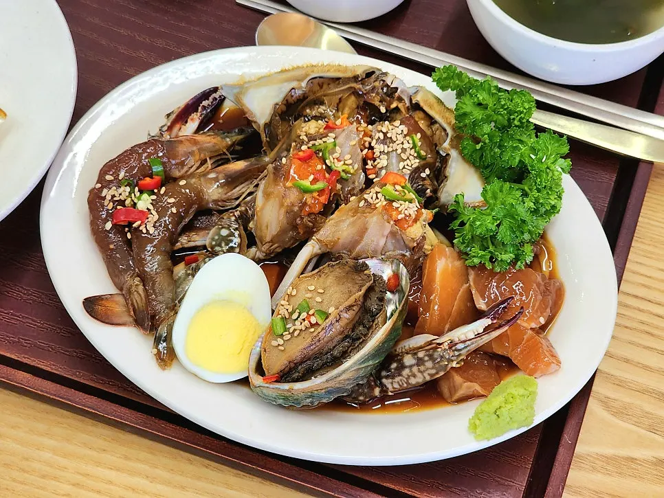 Four soy-marinated items: crab, abalone, shrimp, and salmon