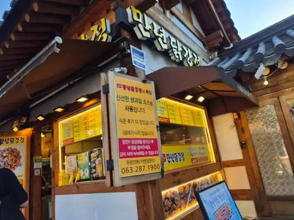 In-store menu sign listing dakgangjeong and shrimp gangjeong