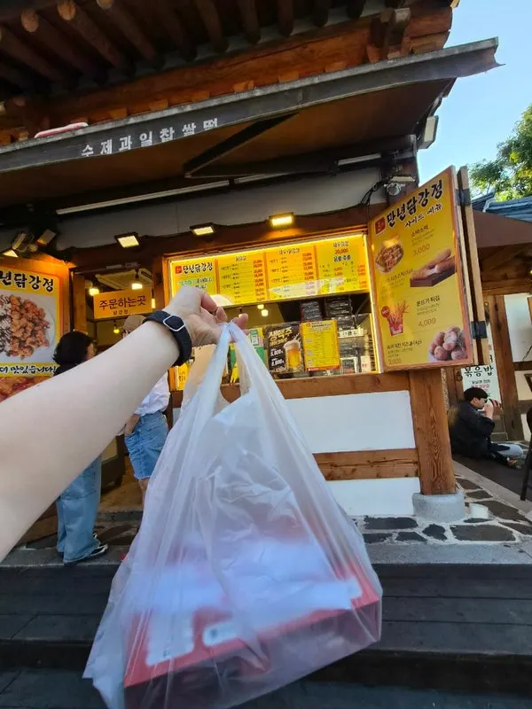 Takeout container of Mannyeon Dakgangjeong carried back to the room