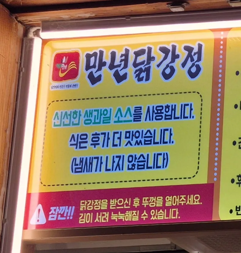 생과일 소스 사용 안내가 담긴 만년닭강정 포장 박스