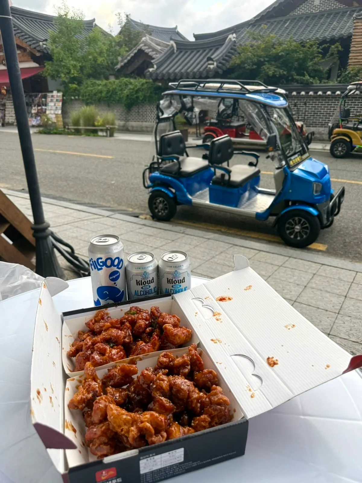 Dakgangjeong and beer at an outdoor convenience store table in the Hanok Village
