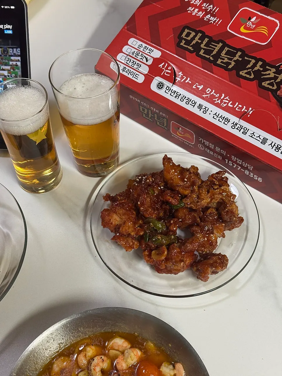 Spicy dakgangjeong served alongside a beer