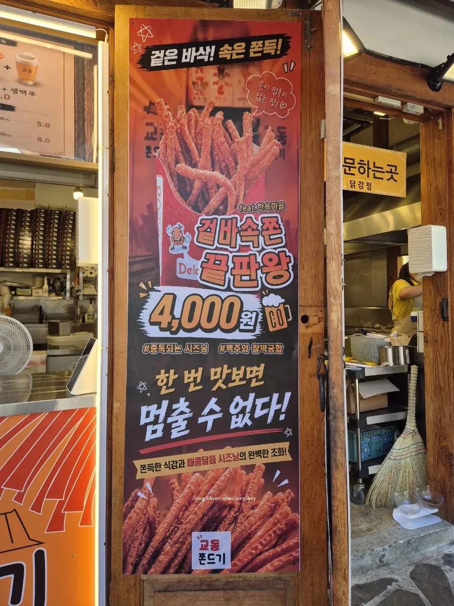 Menu signage and jjondeugi poster outside Mannyeon Dakgangjeong