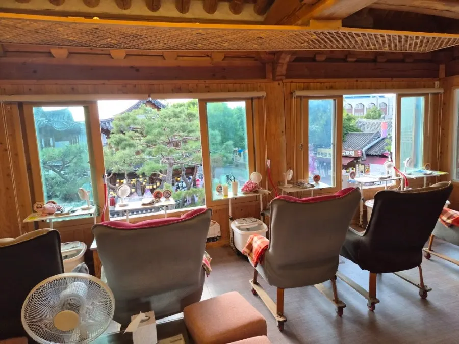 Foot bath chairs lined up along the floor-to-ceiling windows