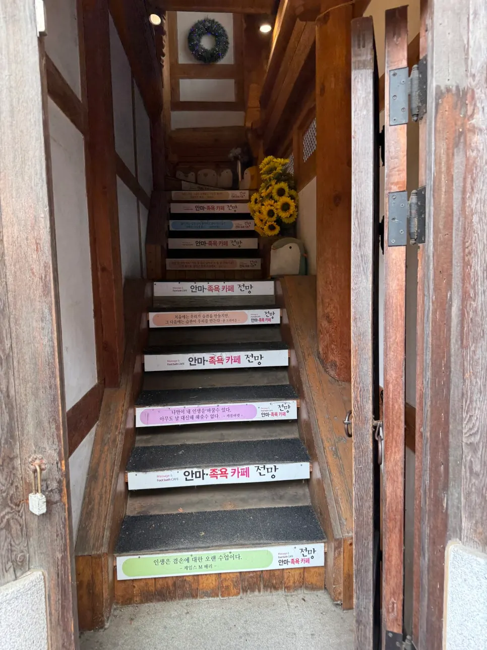 Wooden staircase leading up to the second floor of the hanok building