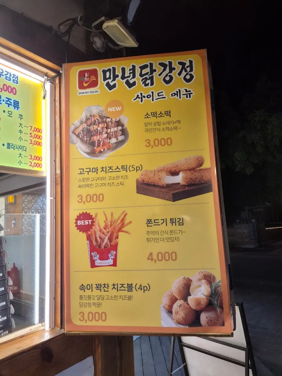 Menu board listing side dishes at Mannyeon Dakgangjeong