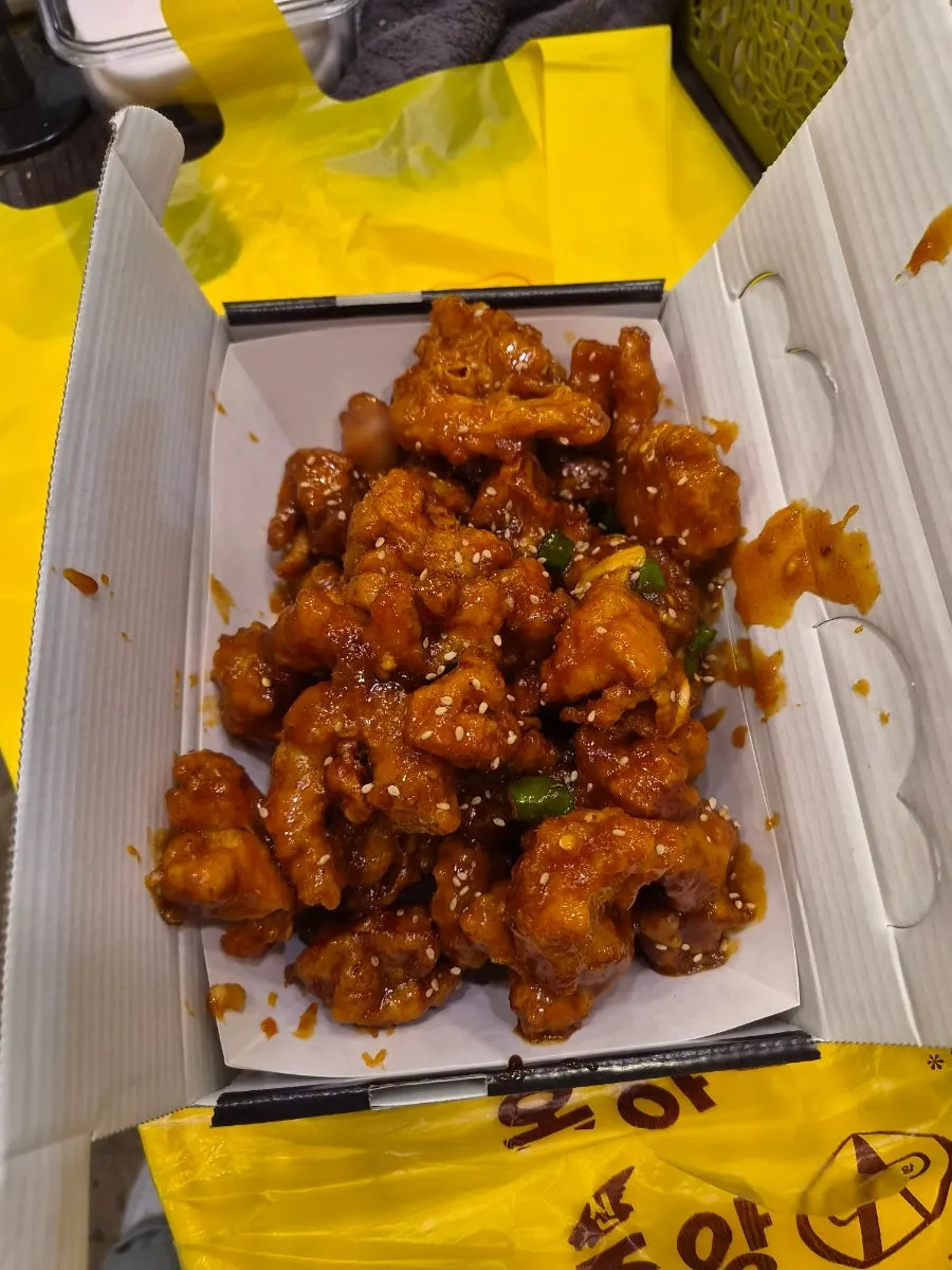 Takeout container of boneless dakgangjeong evenly coated in sauce