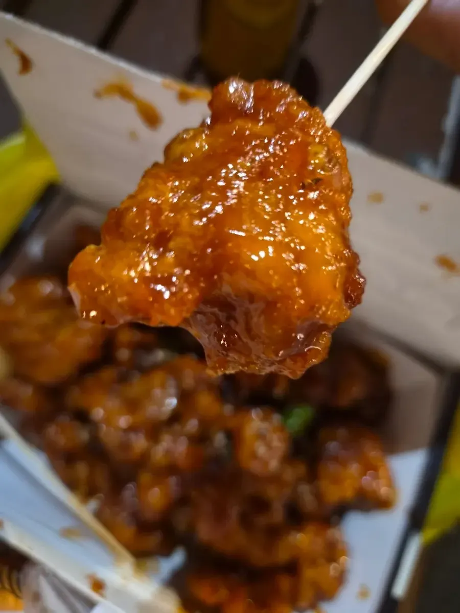 Cross-section of dakgangjeong showing the boneless chicken inside the coating
