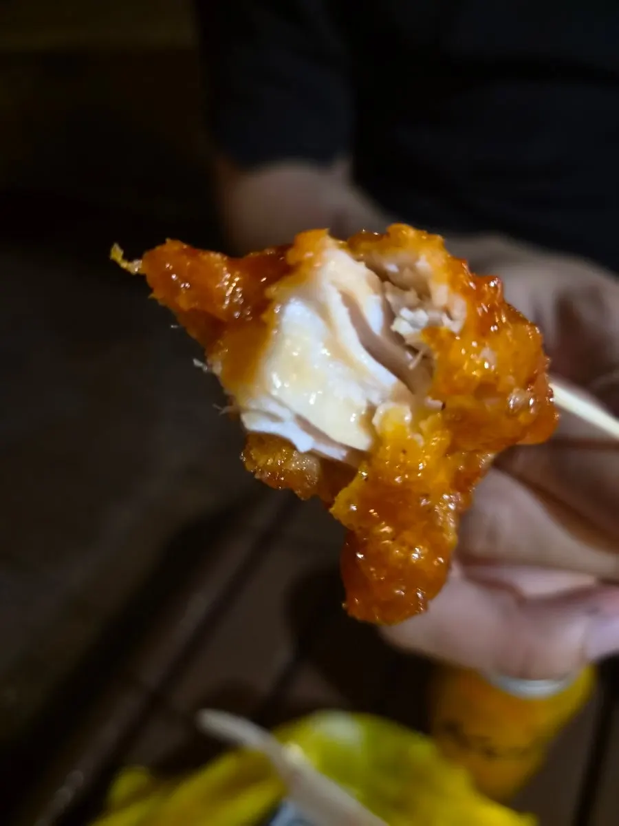 A single piece of boneless dakgangjeong picked up by hand