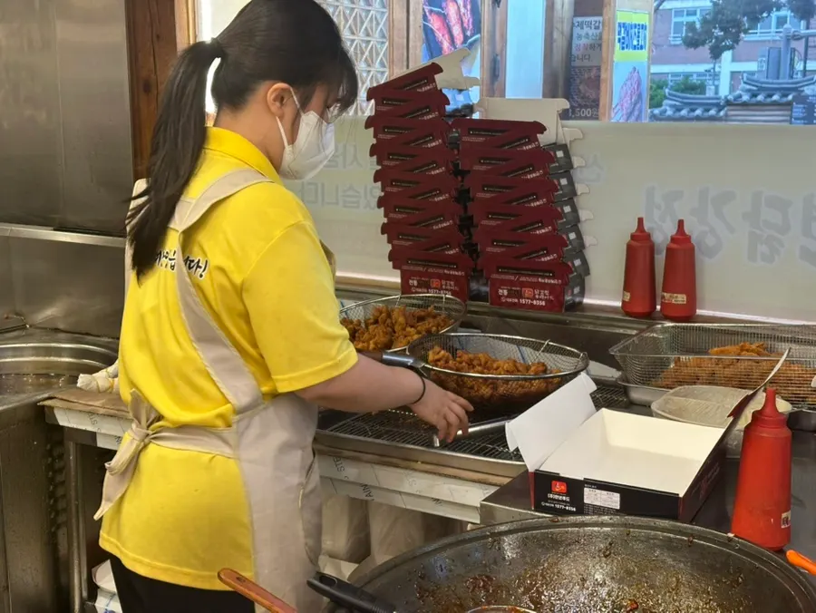 Chicken being tossed and stir-fried in seasoning sauce