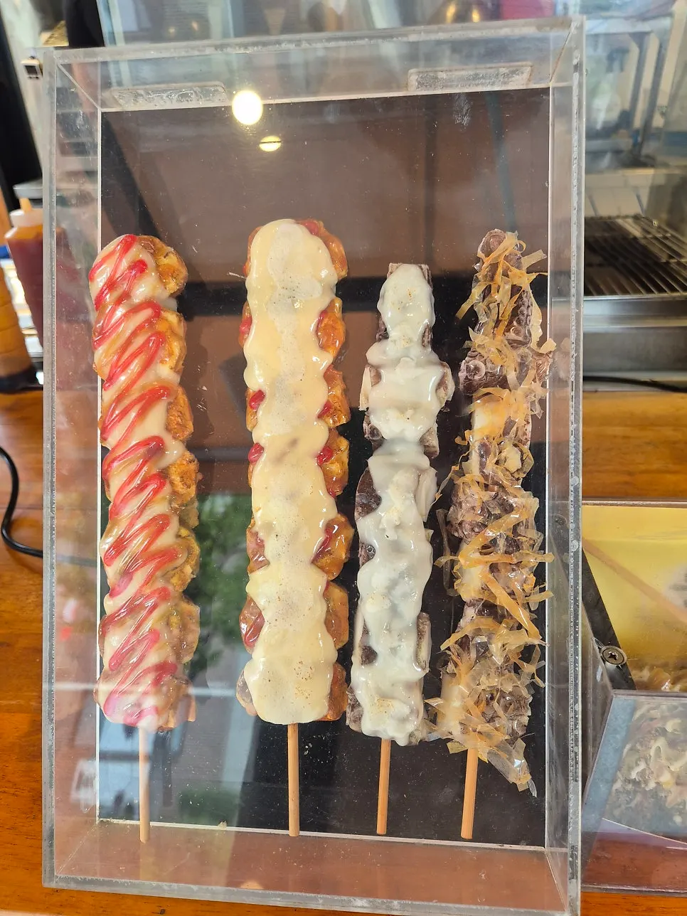 Octopus and chicken skewers arranged on the display case