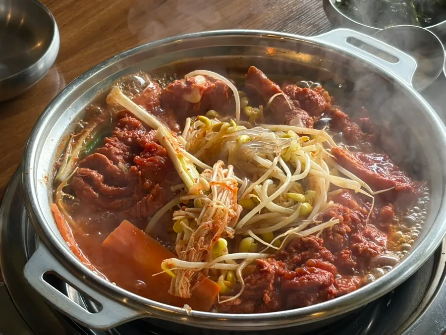 Scored pork rib meat and glass noodles picked up with chopsticks