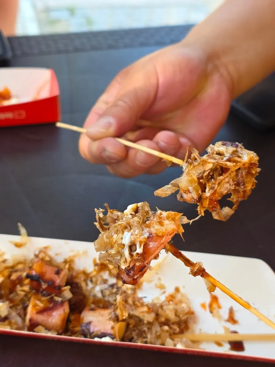 Primer plano de la brocheta de pulpo con abundante katsuobushi