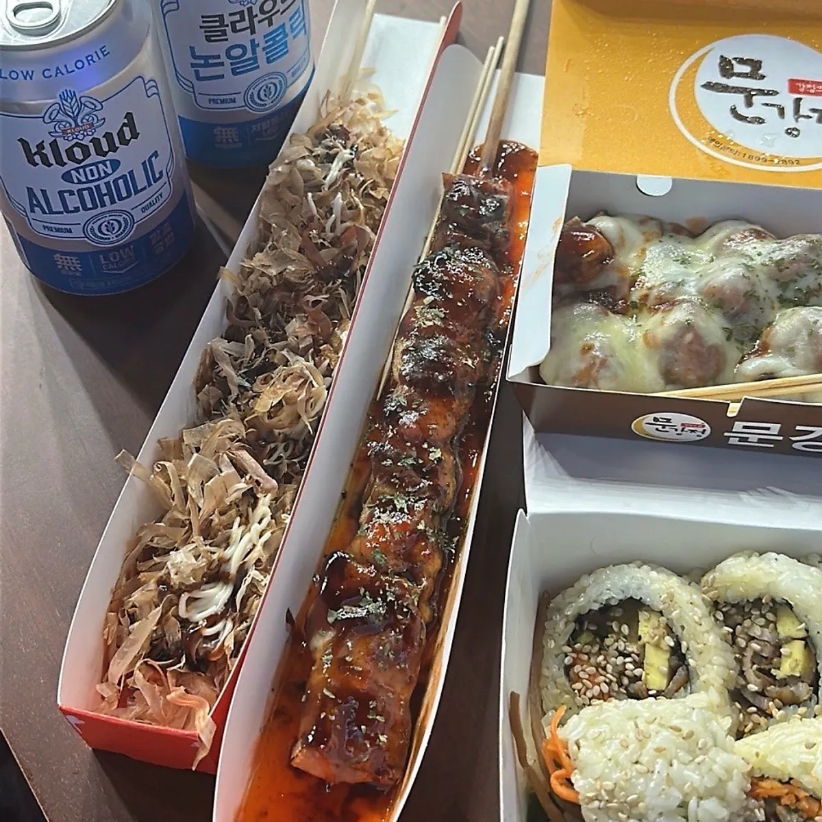 Three skewer snacks arranged with non-alcoholic beer
