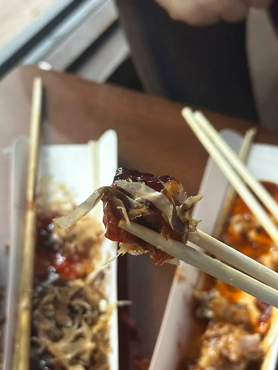 Eating the octopus skewer with chopsticks