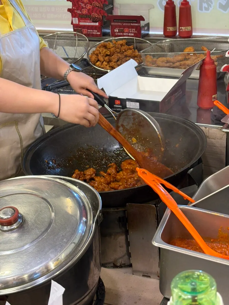 Cooking scene of dakgangjeong being stir-fried in a wok