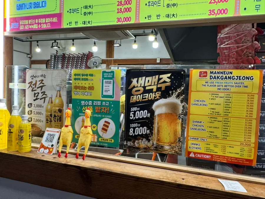 Menu board showing prices for Mannyeon Dakgangjeong's boneless dakgangjeong