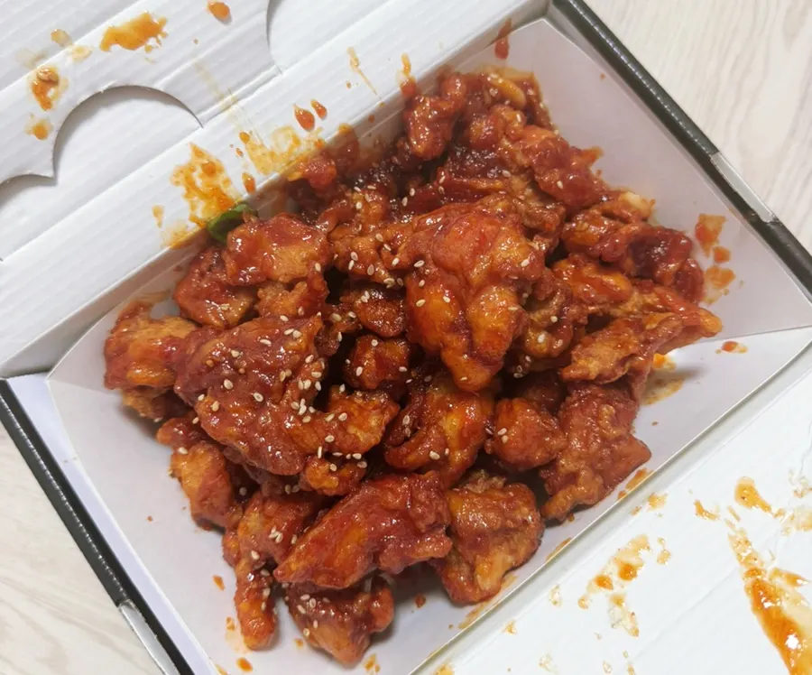 Opened takeout box of spicy dakgangjeong, medium size