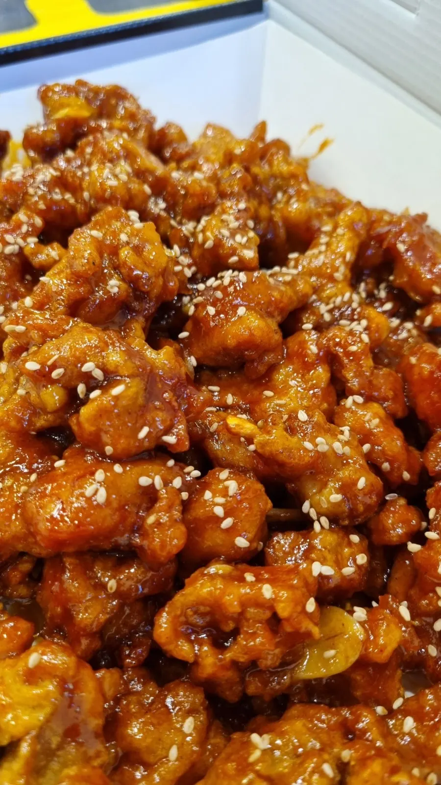 Takeout container of spicy dakgangjeong from Mannyeon