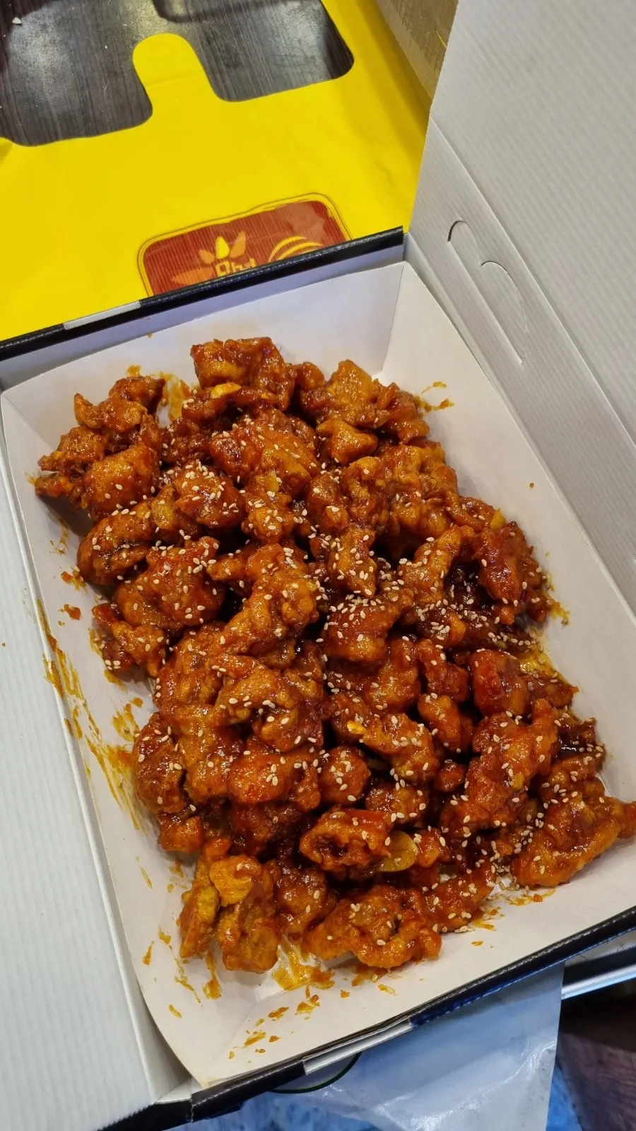 Spicy dakgangjeong takeout box opened inside the car