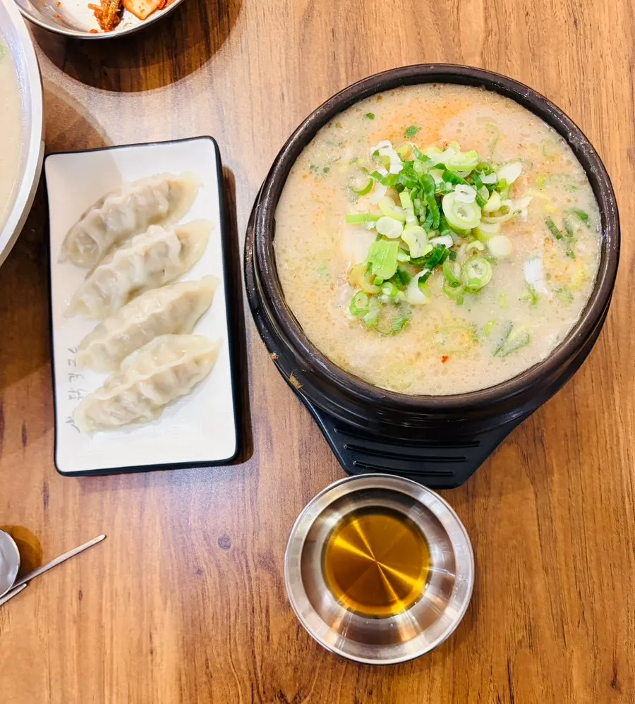 Table with chicken kalguksu, dumplings, and spicy chicken gomtang