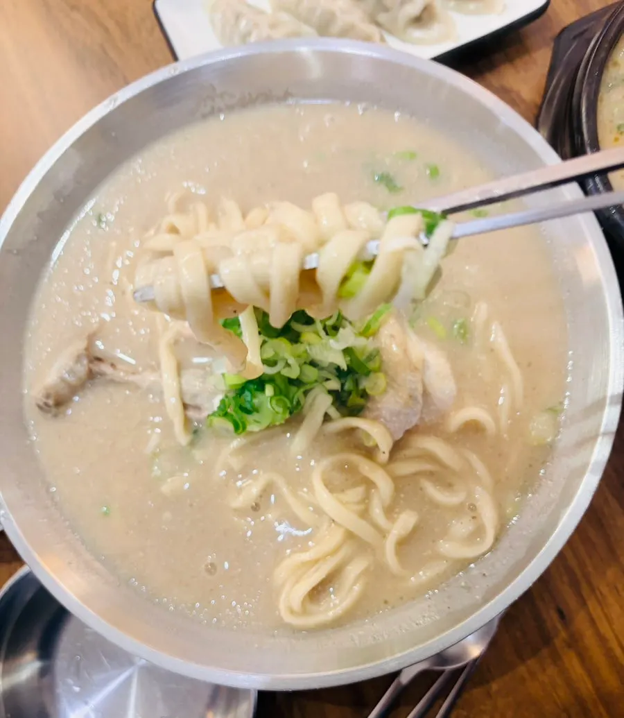 A partially eaten bowl of chicken kalguksu