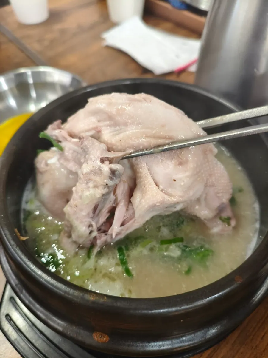 A dumpling dipped in spicy kalguksu broth