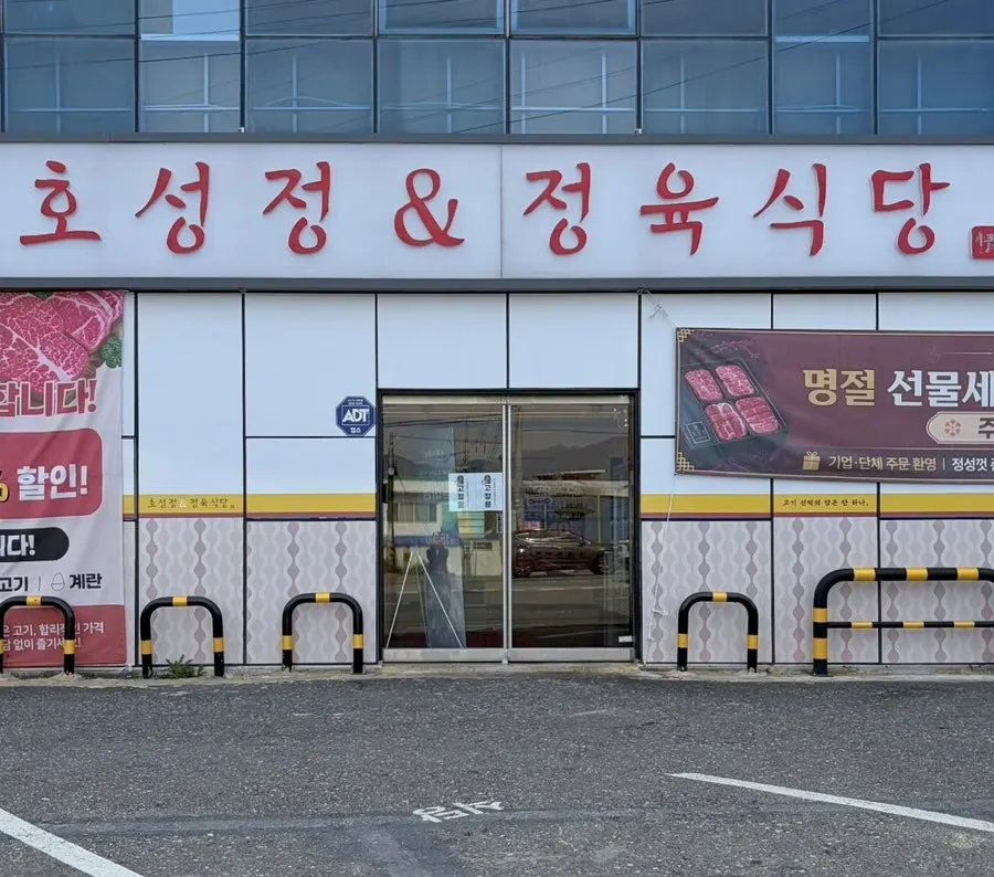 Exterior of Hoseongjeong Butcher's Restaurant in Hoseong-dong, Jeonju, with the parking lot out front