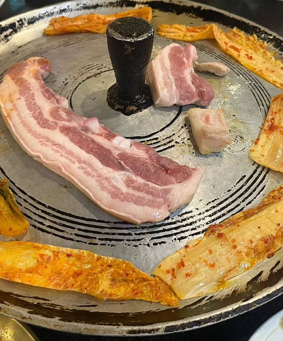 Greasing the cast-iron lid with pork fat
