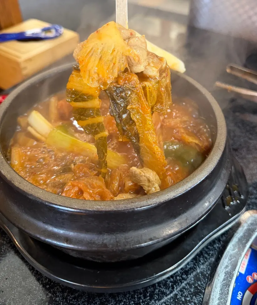 A bite combining meat, grilled kimchi, and garlic
