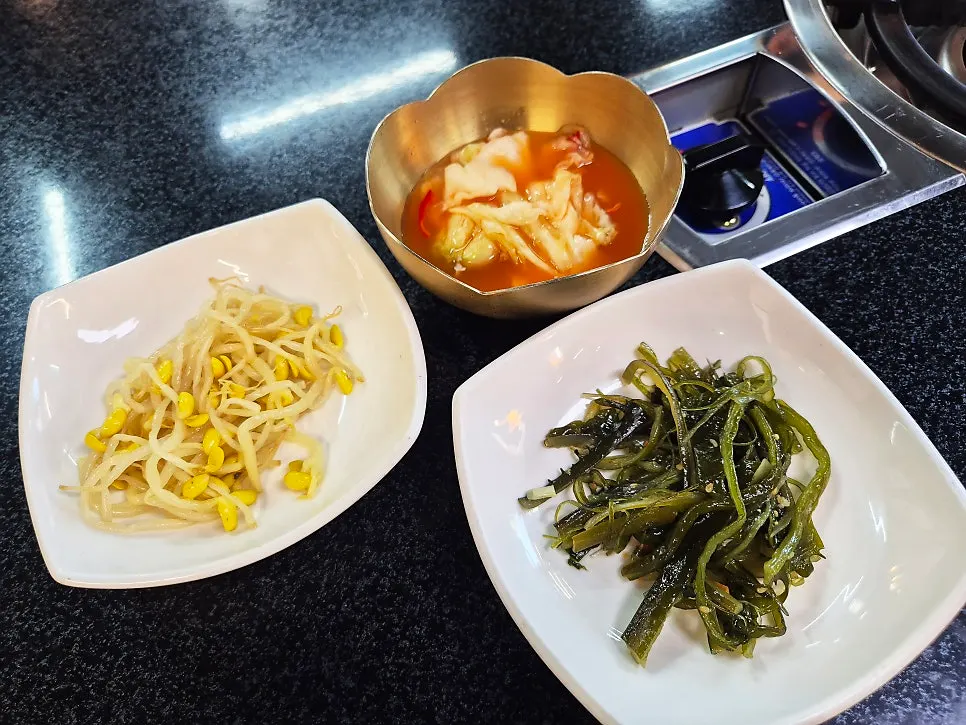 Bean sprouts, stir-fried seaweed stems, and cabbage water kimchi side dishes
