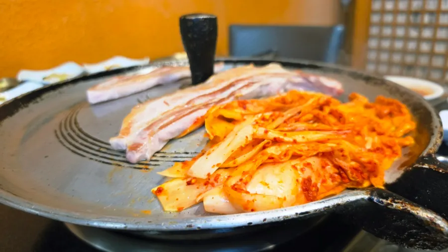 솥뚜껑에 올린 도톰한 생삼겹살