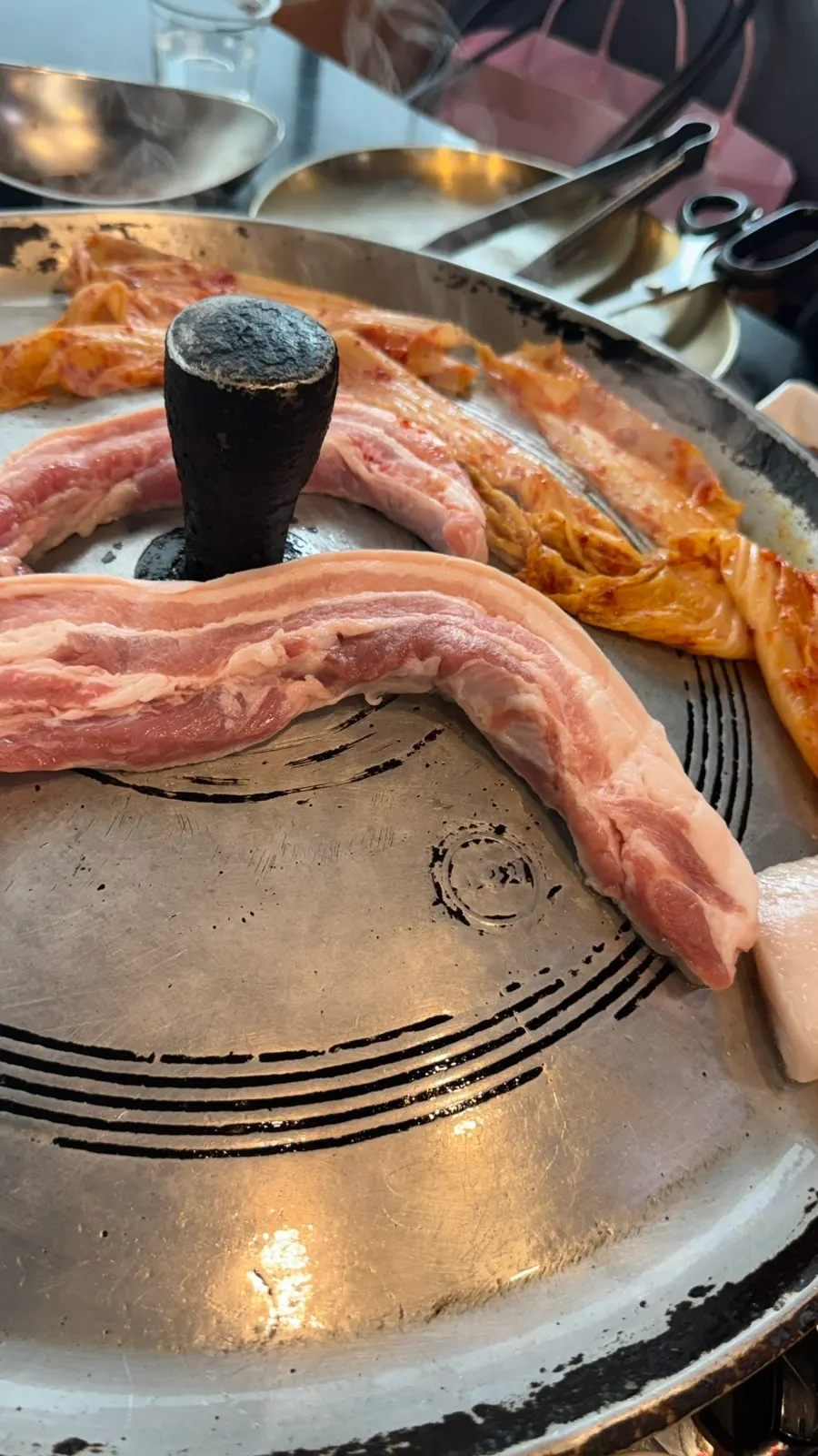Pork belly cooking on the cast-iron lid