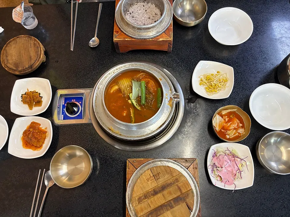Table set with two servings of galbi kimchi stew and jumbo egg roll