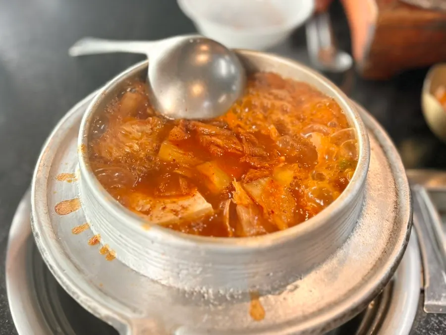 Full table spread of galbi kimchi stew and pot rice