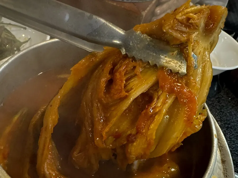 Half head of whole cabbage kimchi added to the stew