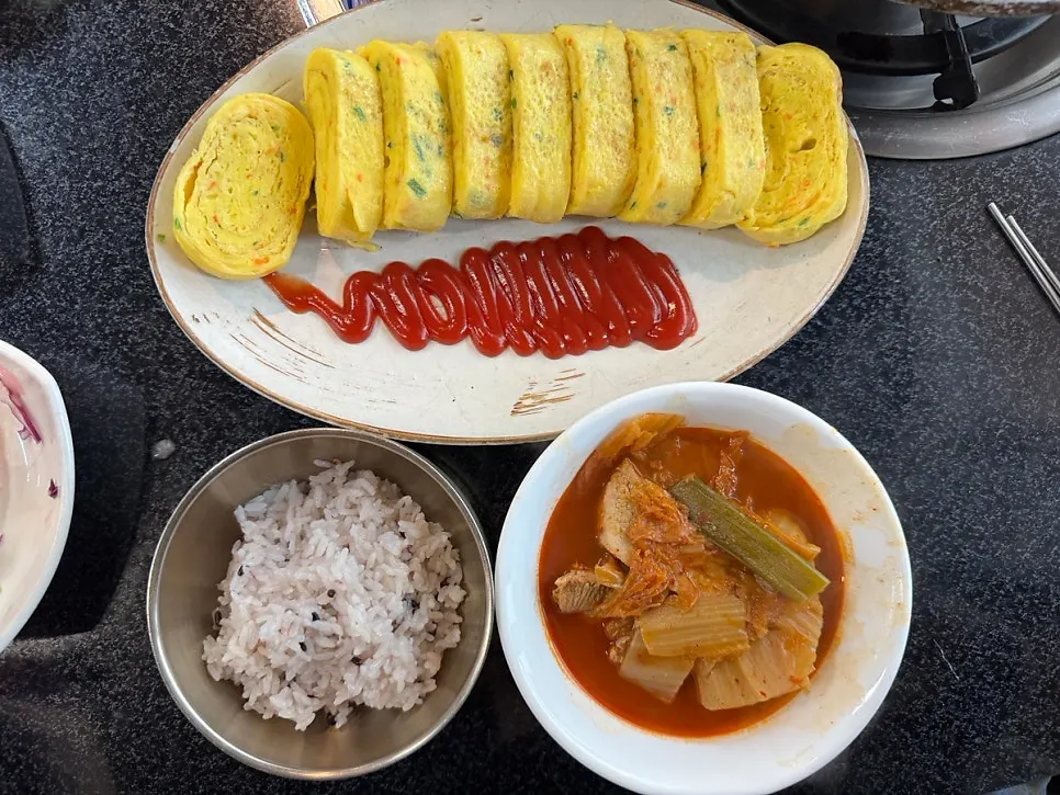 Table spread of egg roll and kimchi stew