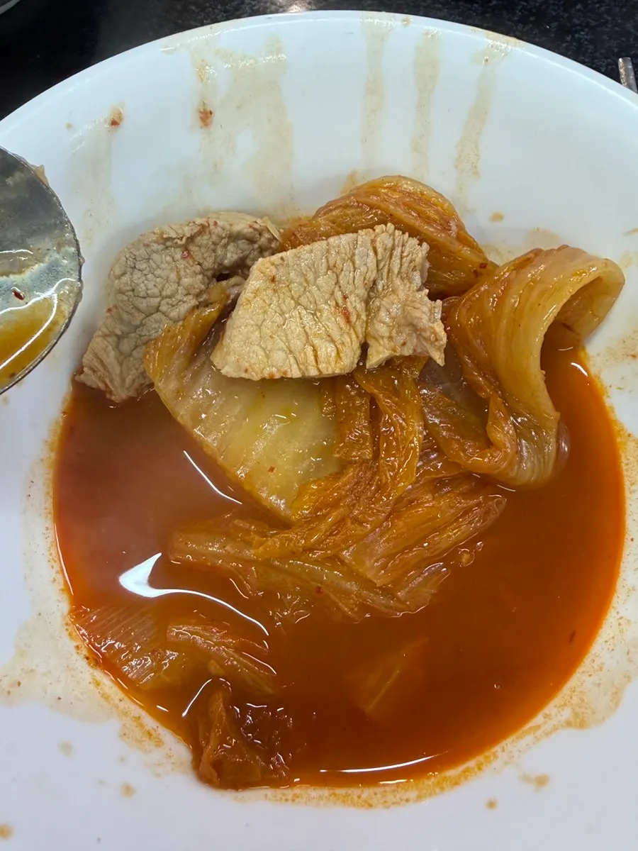 A spoonful of rice topped with aged kimchi