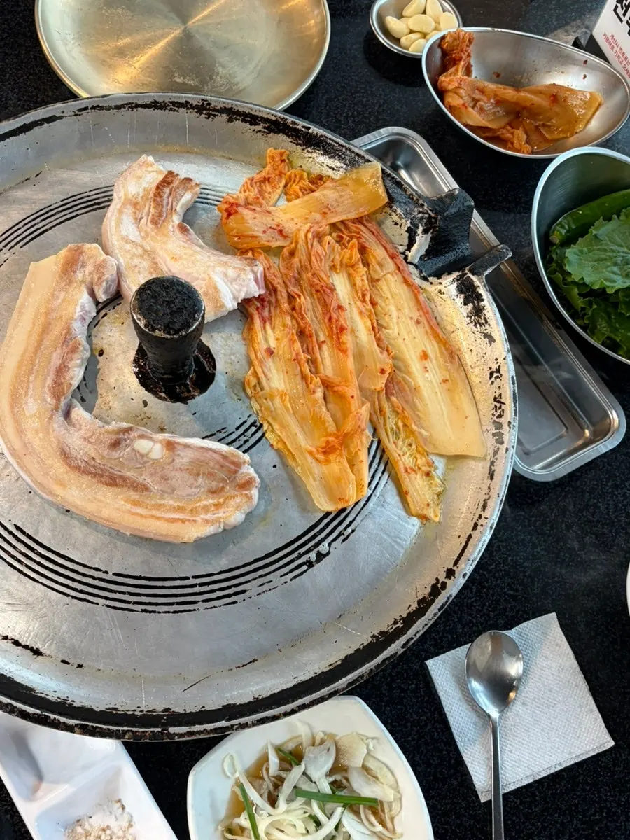 Aged kimchi grilling together with the meat on the cast-iron lid