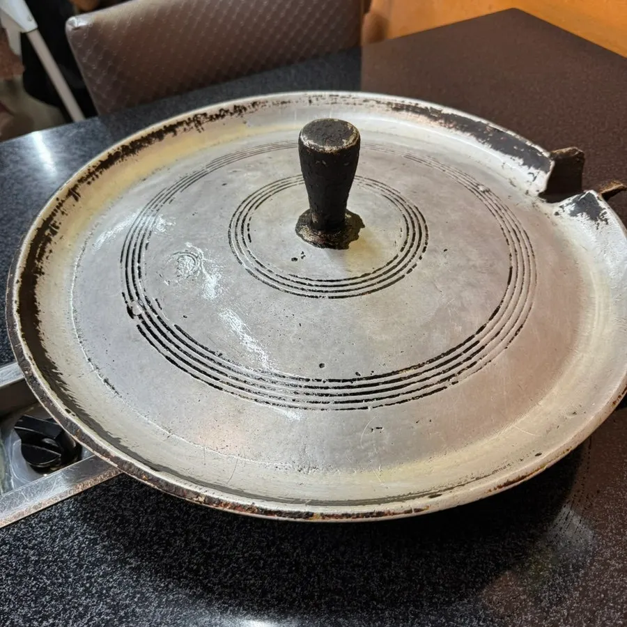 Shiny cast-iron pot lid grill