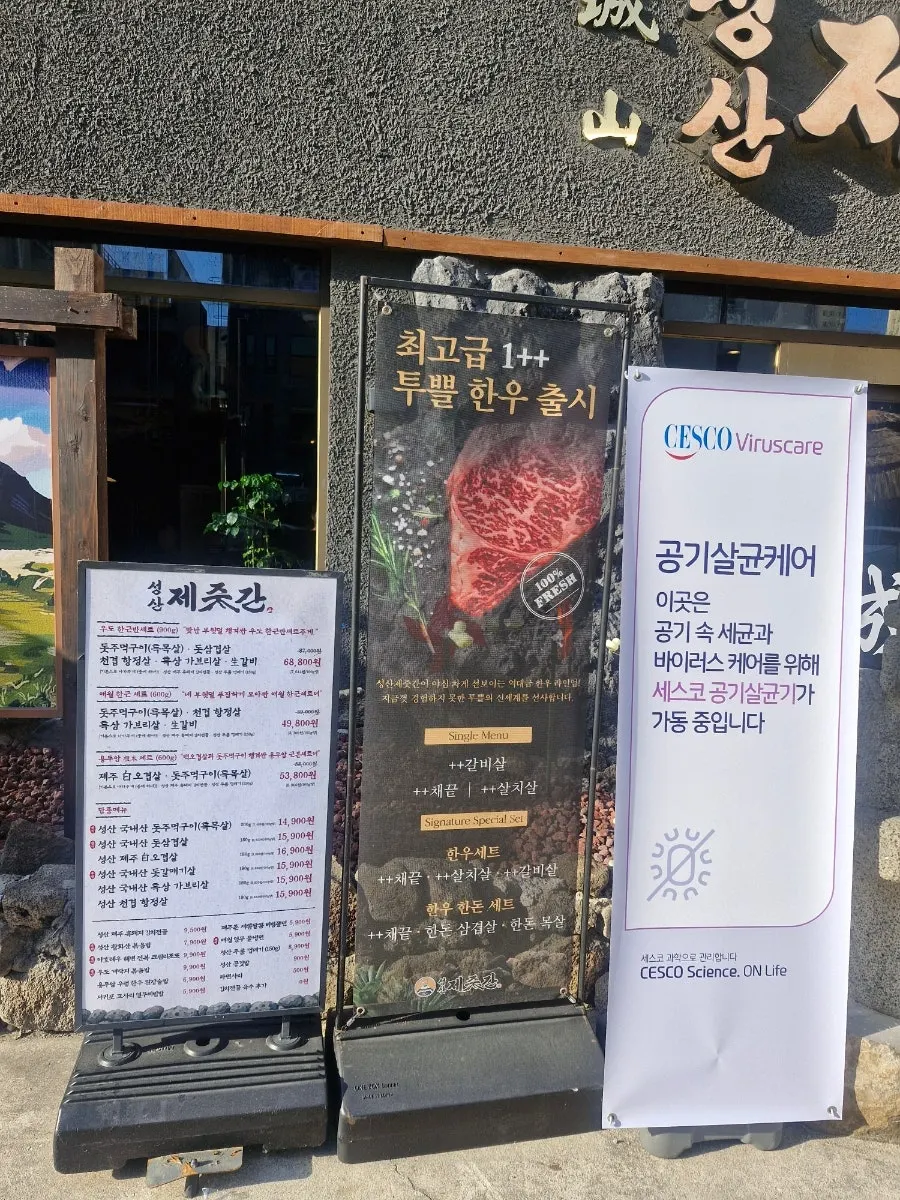 돌담과 돌하르방이 놓인 고기집 입구